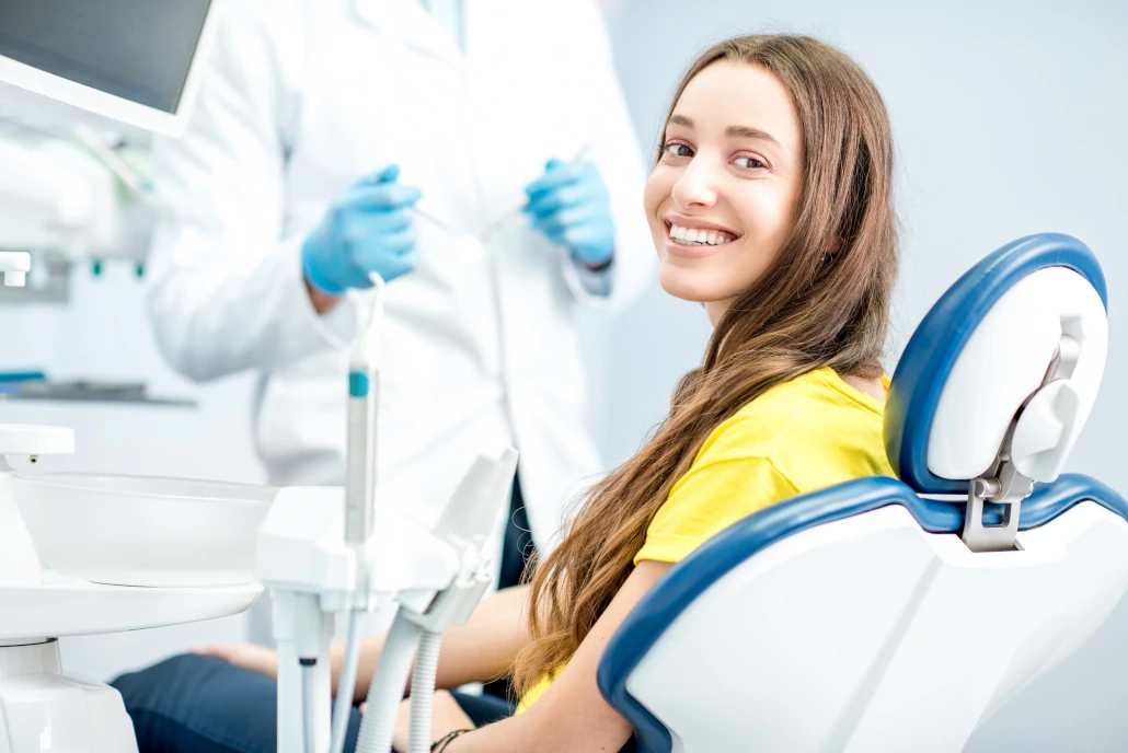 Dentista que realiza odontología preventiva haciendo un chequeo dental de rutina en un paciente sonriente 